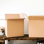 Photo of cardboard moving boxes and books on a table